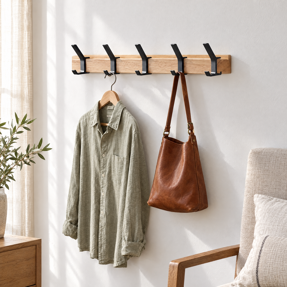 Gancio coat rack on a bedroom wall with a shirt and leather bag