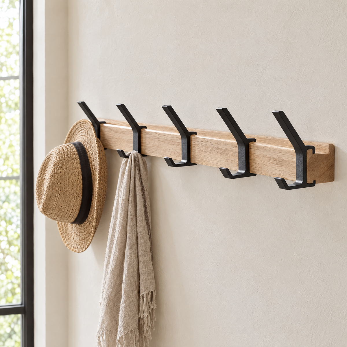 Gancio coat rack from a three-quarter angle with a hat and scarf