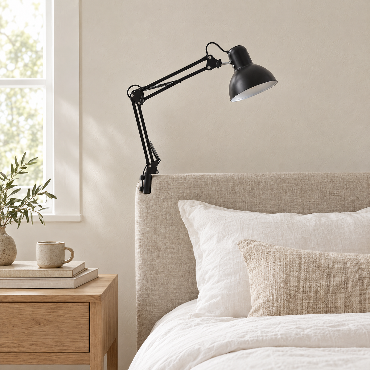 Braccio Clip Table Lamp in black clipped to a linen headboard