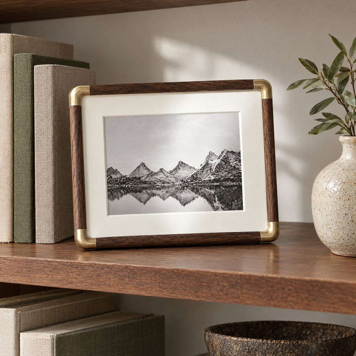 Walnut Cornice photo frame on a bookshelf beside linen-bound books