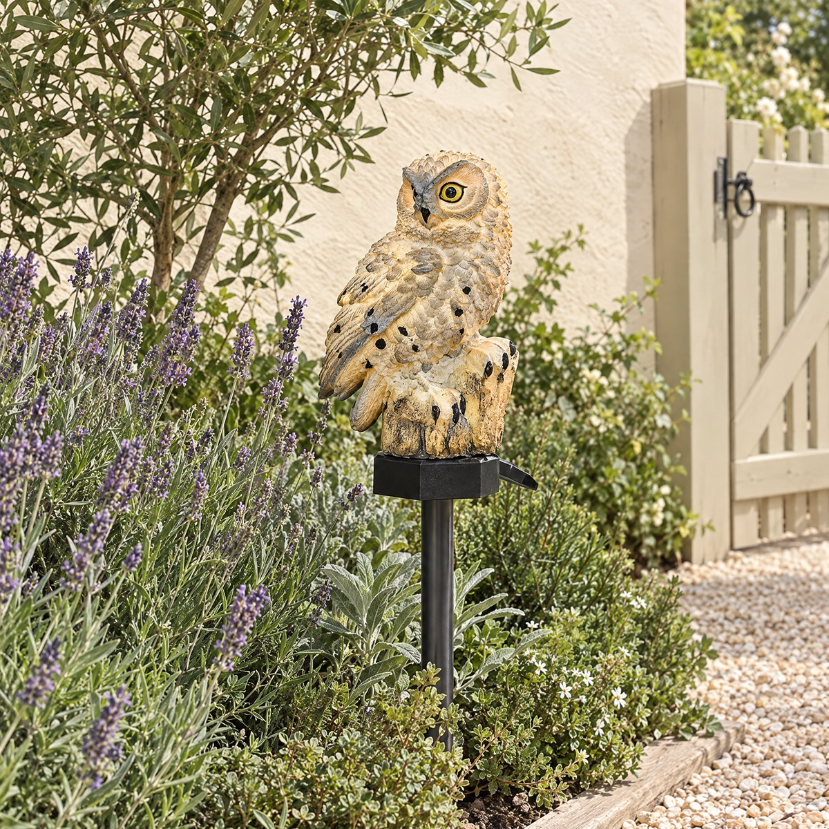 Gufo solar owl light staked in a cottage garden border