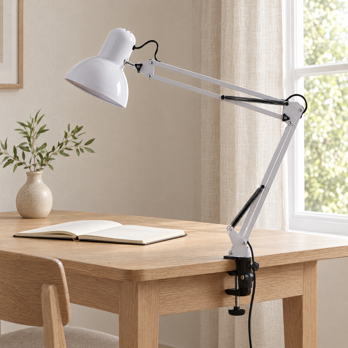 Braccio Clip Table Lamp in white on the edge of an oak desk