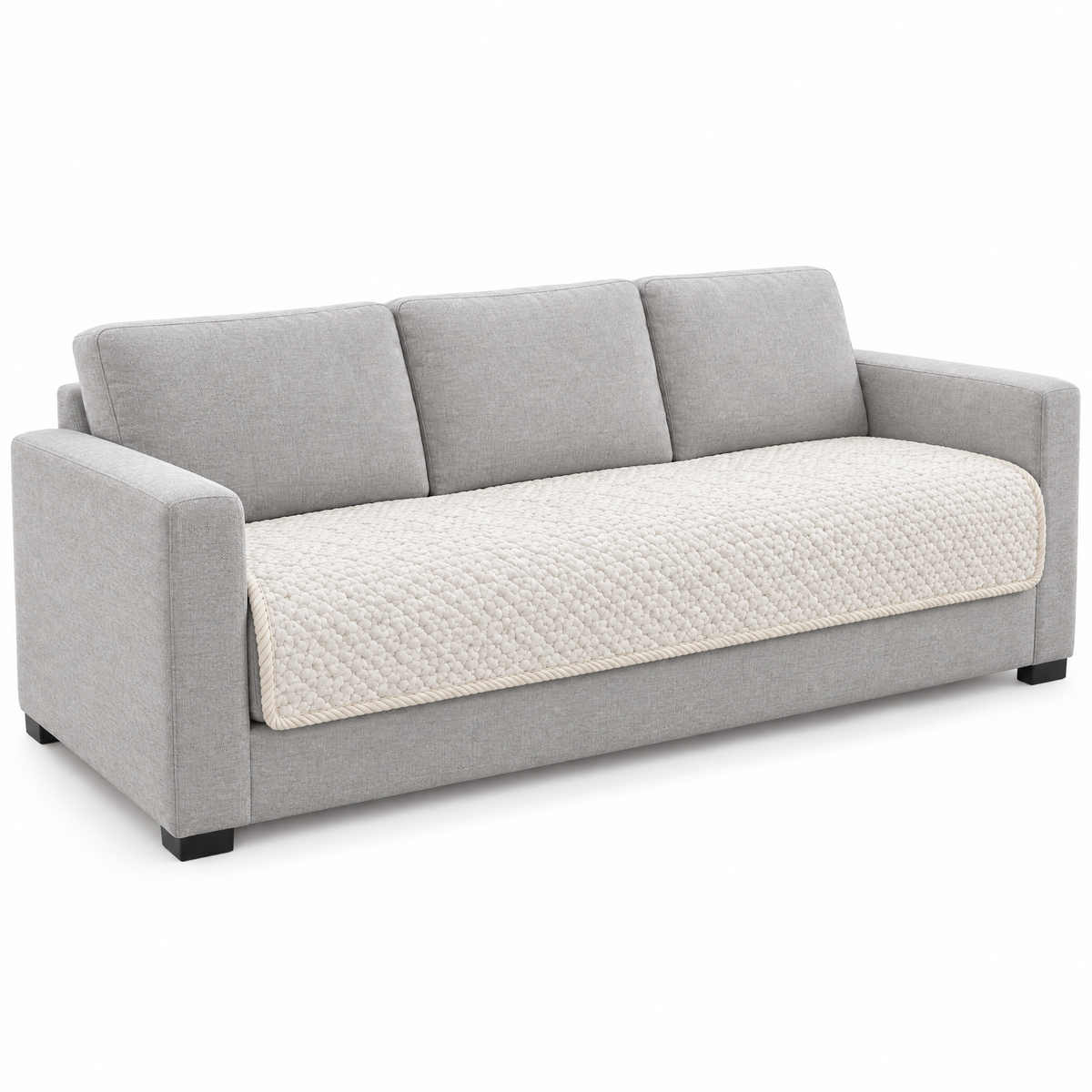 Trapunta Quilted Sofa Cover in ivory on a sofa, white background