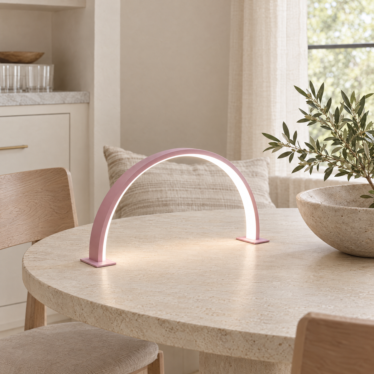 Luna Crescent LED Desk and Nail Lamp in pink on a stone dining table